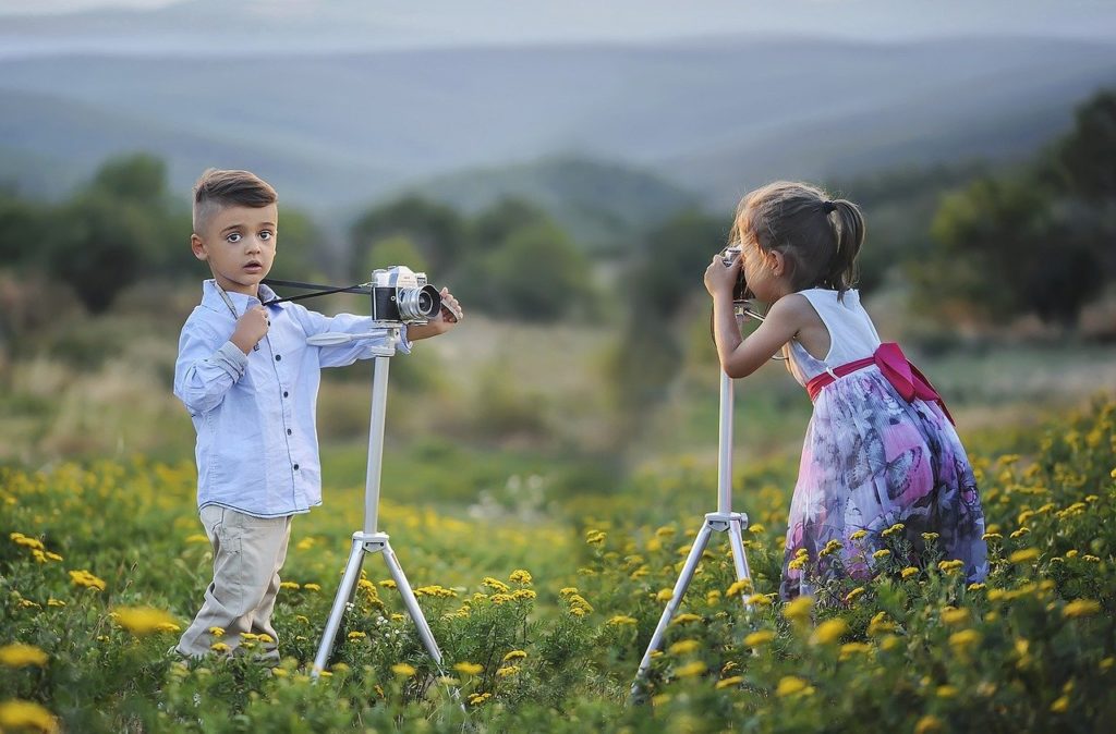 Deux enfants sont dans la nature. Ils prennent des photos. Pour illustrer la mémoire des apprentissages par observation grâce aux neurones miroirs.